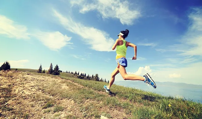 A trail runner on a grassy ridge